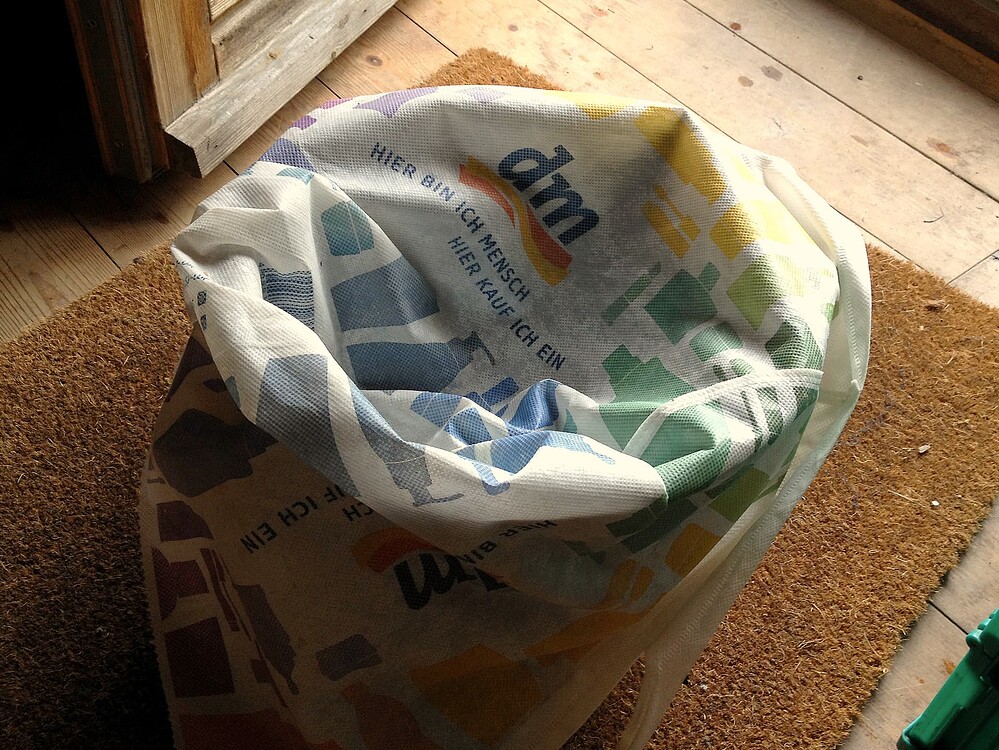 Eine dm-Einkaufstasche aus Recycling-Gewebe, die als Filter für einen Schachtelhalmsud verwendet wird.