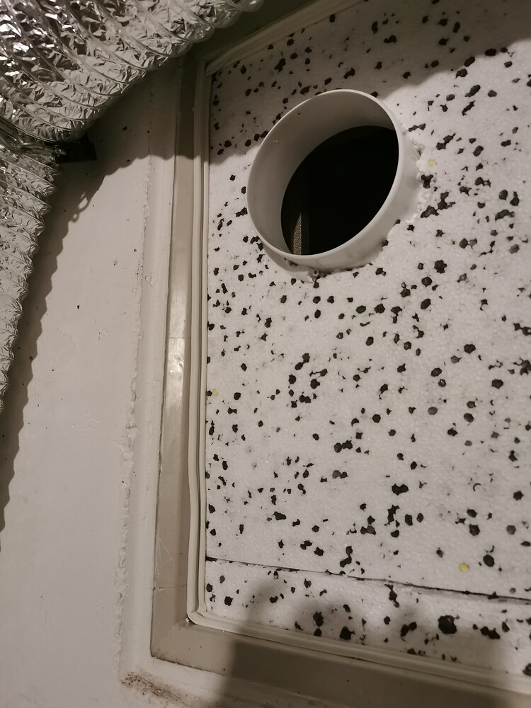 Selbstgebaute Fensterabdichtung aus Styropor mit Abluftflansch für ein Grow-Zelt.